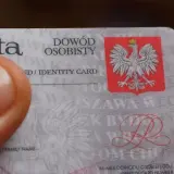 Zgubiony dowód osobisty. Kciuk zasłania część dokumentu z godłem Polski.