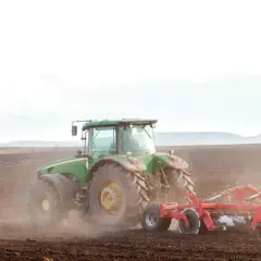 Zielony traktor orze pole. To symbol przekazania gospodarstwa rolnego, które pozwala na opiekę nad rodzicami i dalszy rozwój.
