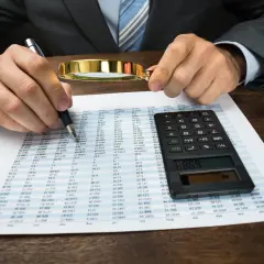 Kontrola dokumentów finansowych z lupą i kalkulatorem. Kara porządkowa ordynacja podatkowa.