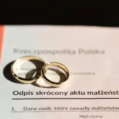 Złote obrączki na odpisie skróconym aktu małżeństwa. Zastanawiasz się, ile kosztuje akt małżeństwa? Dokument z pieczęcią Urzędu Stanu Cywilnego w Katowicach.