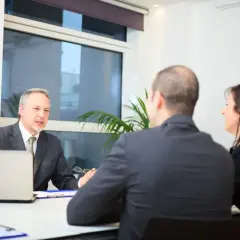 Rozmowa o tym, ile kosztuje pełnomocnictwo notarialne. Notariusz tłumaczy szczegóły klientom.