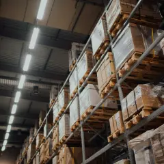 Wysokie regały magazynowe wypełnione paczkami, gotowe do wysyłki. To miejsce, gdzie realizuje się umowa przechowania.
