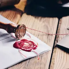 Pieczęć notarialna i dokumenty z czerwonym woskiem, symbolizujące rozporządzenie taksa notarialna.