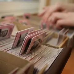 Ręce przeszukują kartoteki z dokumentami. Gdzie jest numer dowodu osobistego?