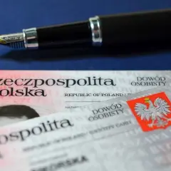 Uszkodzony dowód osobisty leży obok pióra. Dokument tożsamości Rzeczypospolitej Polskiej jest lekko porysowany.