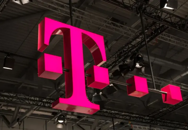 Trójwymiarowe, różowe logo T-Mobile zawieszone pod sufitem hali.
