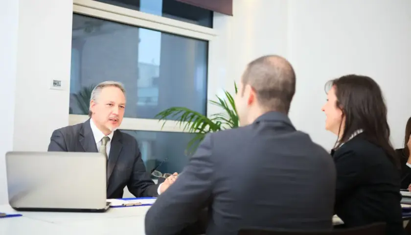 Rozmowa o tym, ile kosztuje pełnomocnictwo notarialne. Notariusz tłumaczy szczegóły klientom.