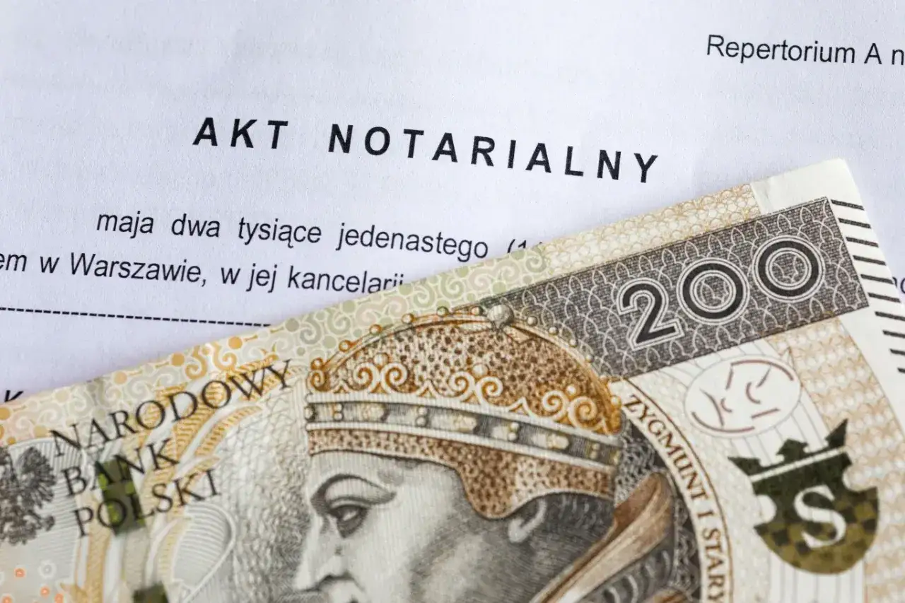 Akt notarialny i banknot 200 zł. Dokument może dotyczyć umowy darowizny lub innej transakcji.