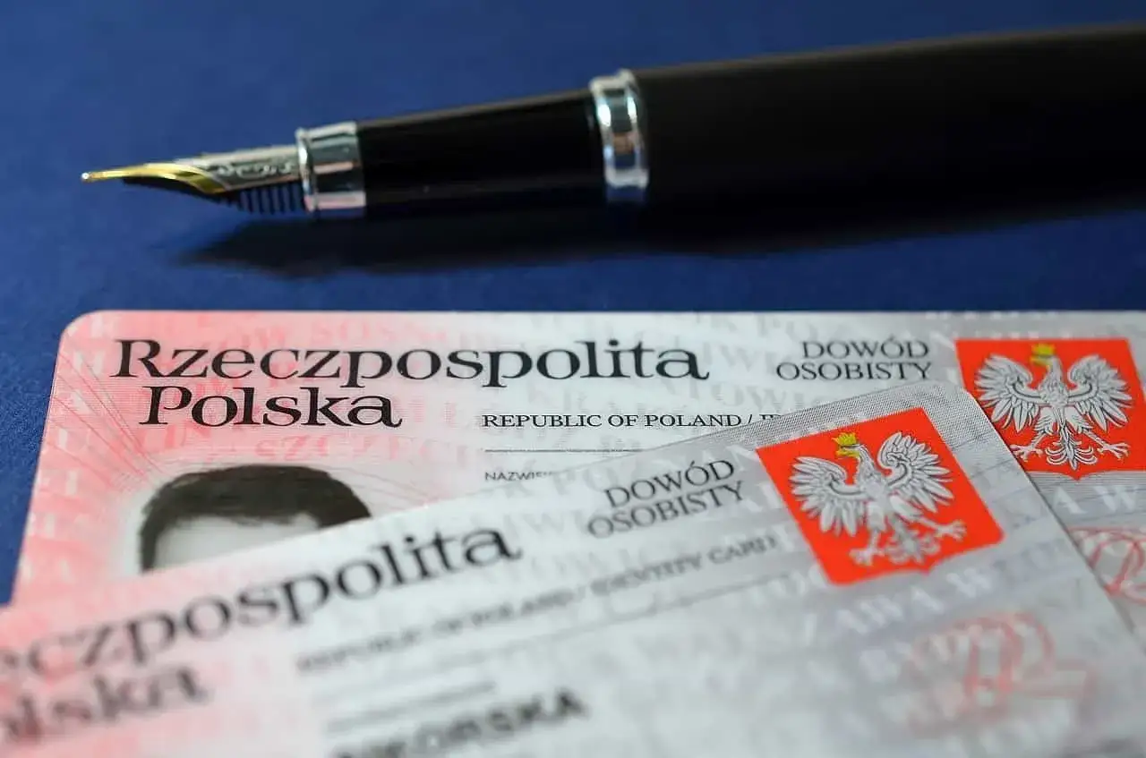 Uszkodzony dowód osobisty leży obok pióra.